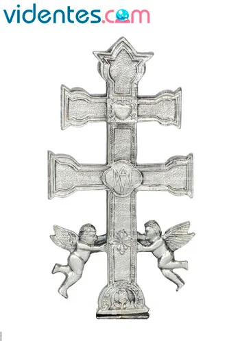Cruz de Caravaca junto a una vela blanca en un ritual de protección
